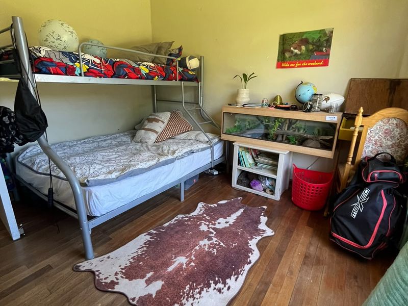 A bedroom featuring timber flooring and coved ceilings, offering a functional space with potential for cosmetic updates.