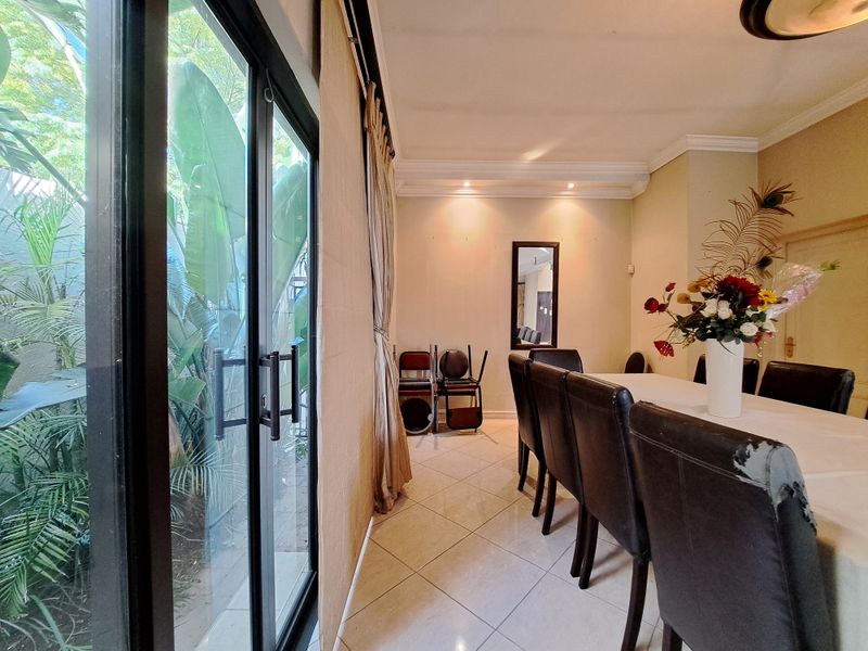 Dining room featuring tiled flooring, recessed lighting, crown molding, and a large sliding glass door providing access to the garden area.