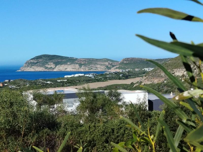 A scenic elevated view overlooking the coastal landscape, ocean, and surrounding hills from the residential property.