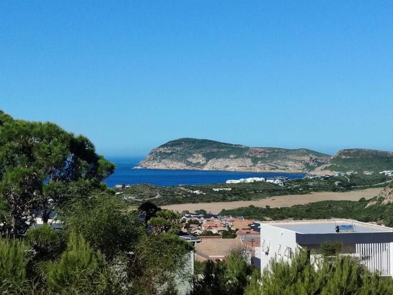 A scenic elevated view overlooking the coastline, featuring rolling hills, ocean waters, and surrounding residential development.