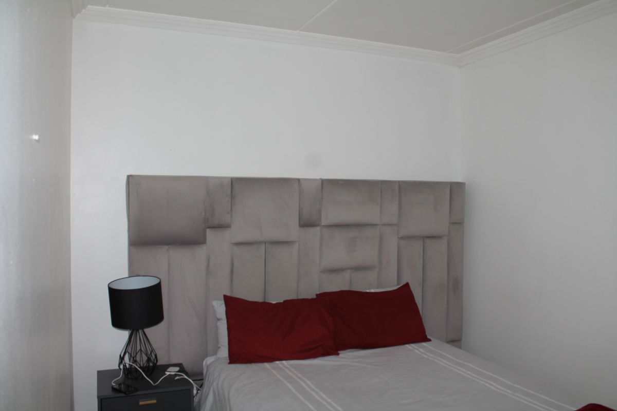 A simple bedroom featuring white walls and crown molding, providing a neutral base for interior design updates.