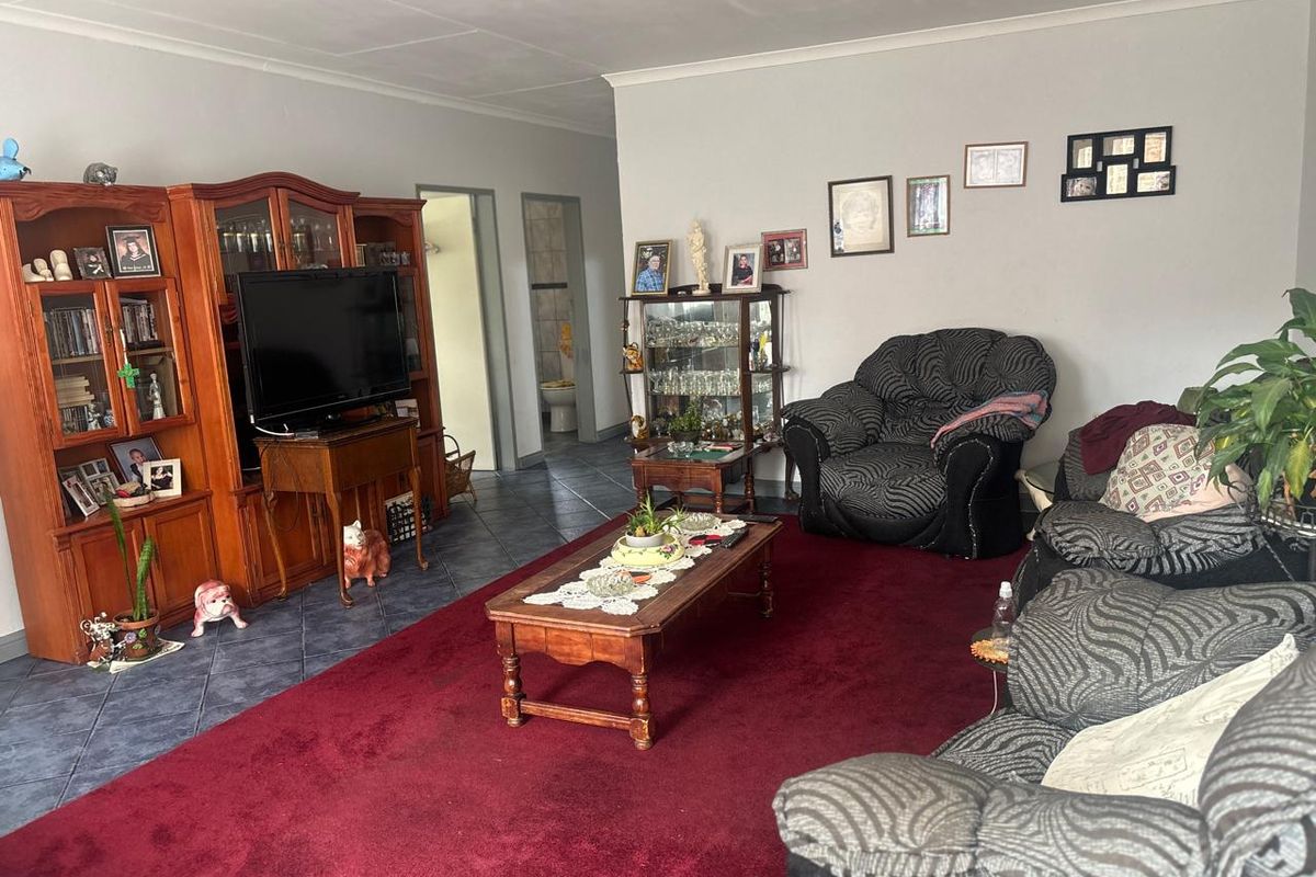 A spacious living room featuring tiled flooring and neutral wall finishes, providing a comfortable area for relaxation and family gatherings.