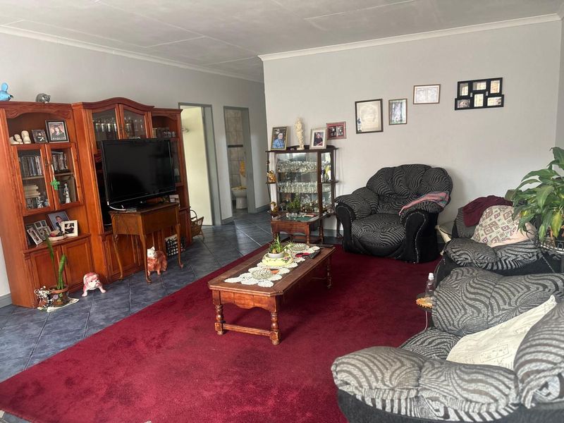 A spacious living room featuring tiled flooring and neutral wall finishes, providing a comfortable area for relaxation and family gatherings.