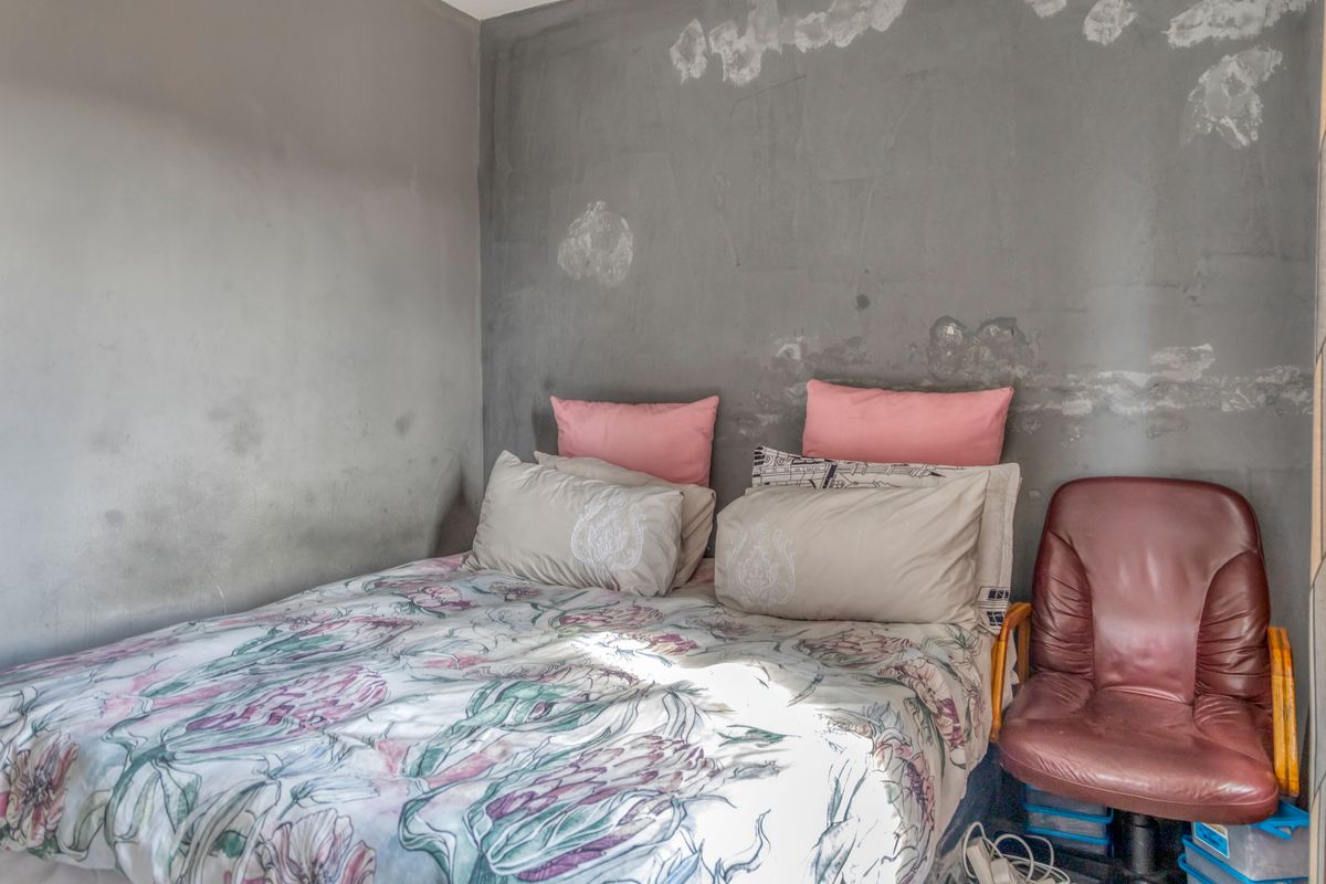 A bedroom featuring walls with significant surface damage and visible moisture staining, requiring repair and repainting to restore the space.