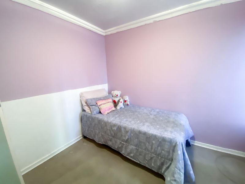 A bedroom featuring two-tone painted walls and crown molding, requiring cosmetic updates to the wall finishes.
