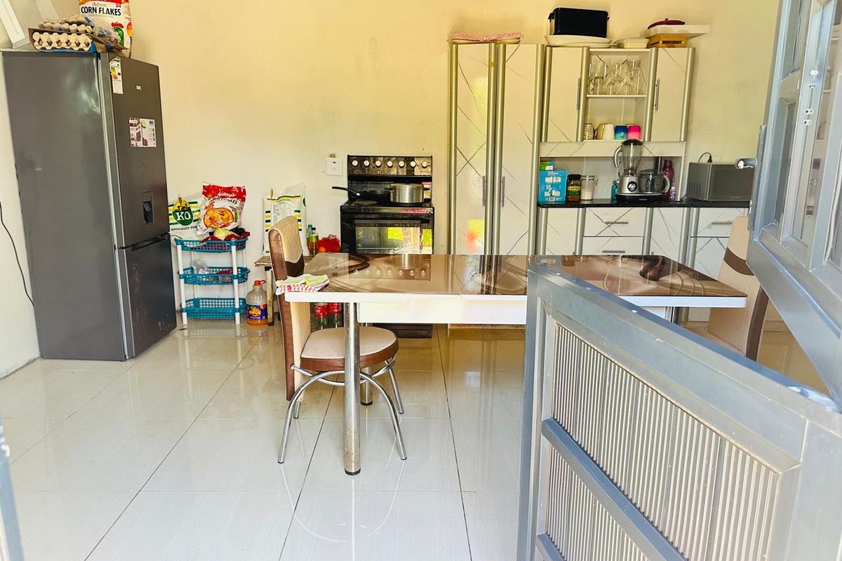 A functional kitchen area featuring tiled flooring, built-in cabinetry, and a freestanding stove, providing a practical space for cooking and dining.