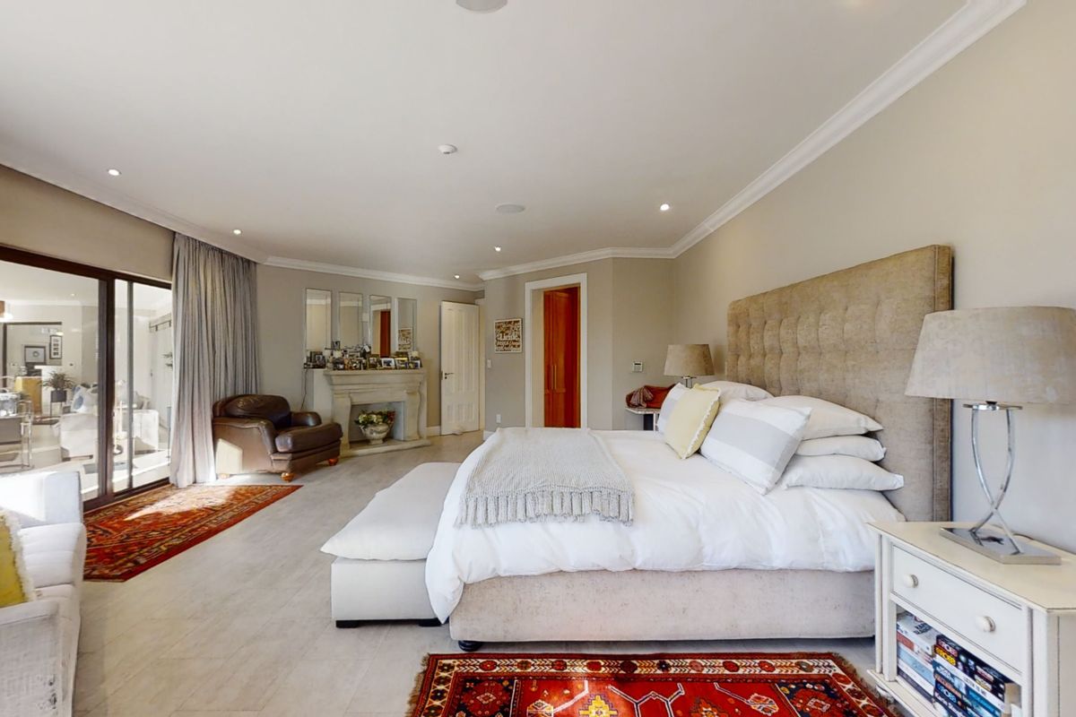 Spacious bedroom featuring a fireplace, recessed lighting, crown molding, and large sliding glass doors providing access to an adjoining living area.