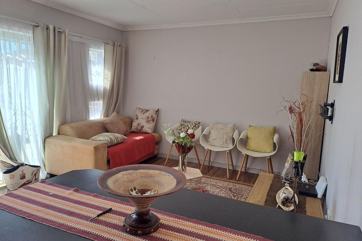 A living room area featuring laminate flooring and a sliding glass door providing natural light.