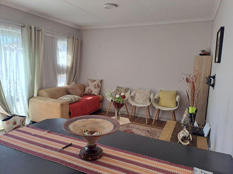 A living room area featuring laminate flooring and a sliding glass door providing natural light.
