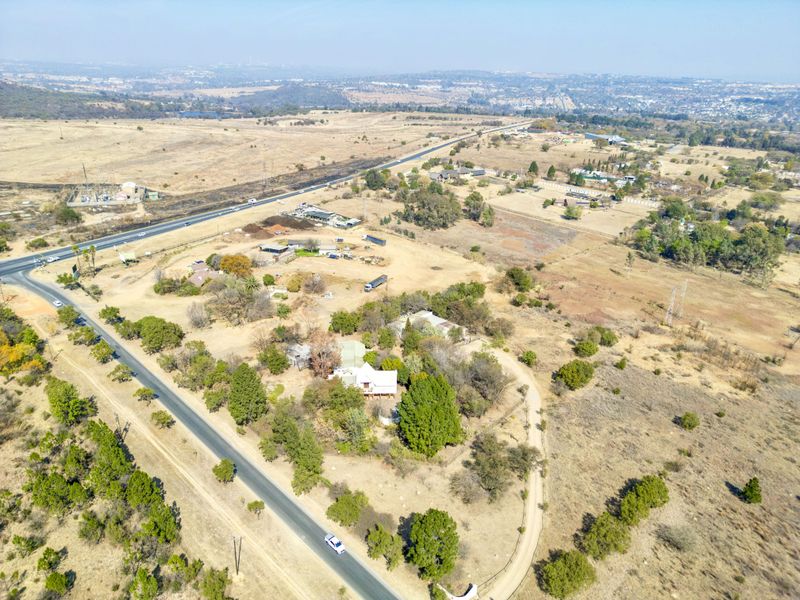 An aerial view of the small holding property, showcasing the surrounding landscape, access roads, and existing vegetation.