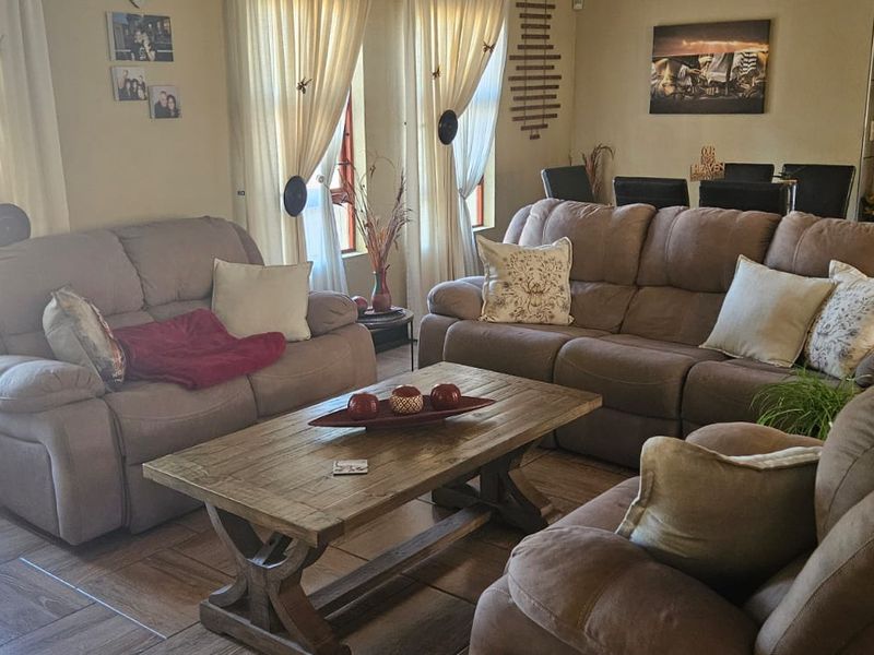 A comfortable living room featuring tiled flooring and natural light through large windows, providing a functional and inviting space for relaxation.