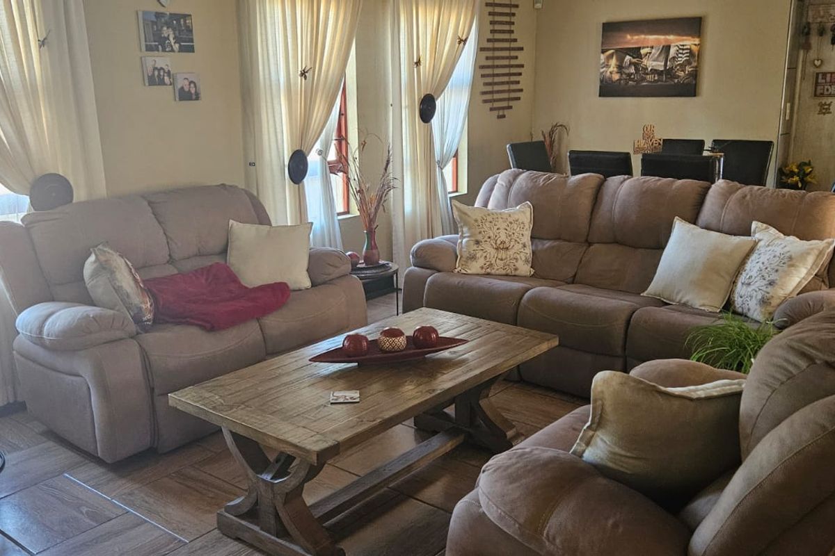 A comfortable living room featuring tiled flooring and natural light through large windows, providing a functional and inviting space for relaxation.