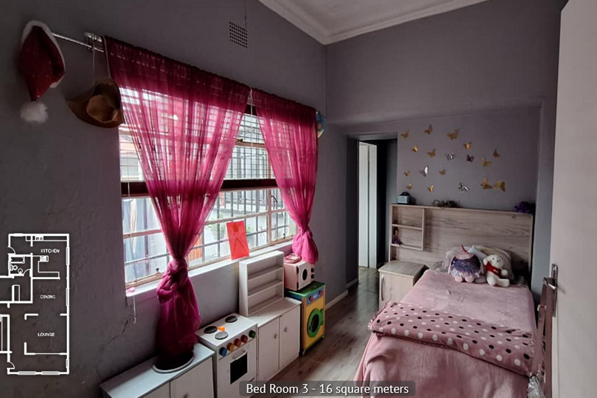 A bedroom featuring wood-look flooring, a built-in headboard with shelving, and a large window with security bars.