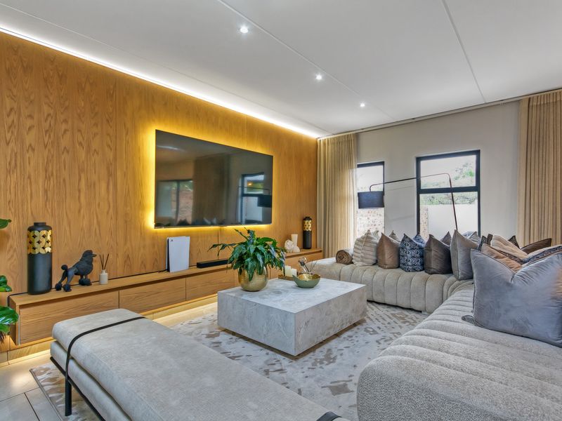 Modern living room featuring a wood veneer feature wall with integrated LED lighting, built-in floating cabinetry, and recessed downlights.