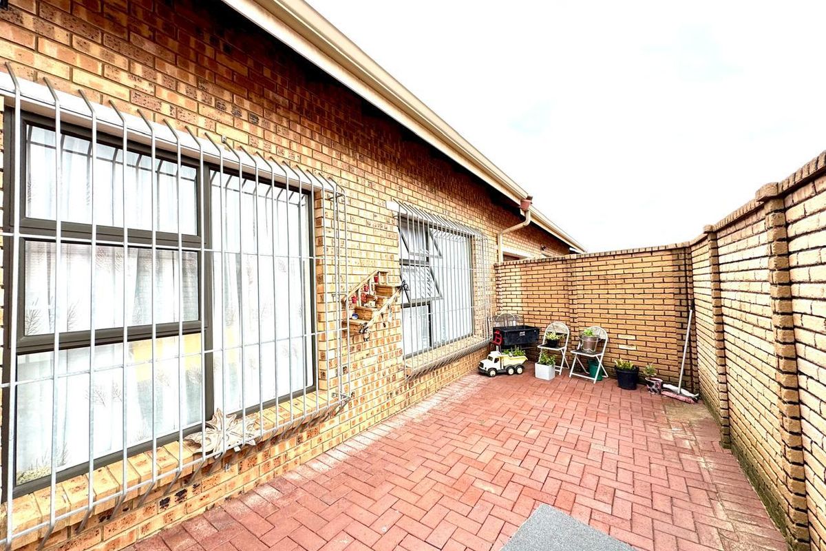 A private rear courtyard featuring brick paving and a high brick boundary wall, providing a secure and low-maintenance outdoor space.