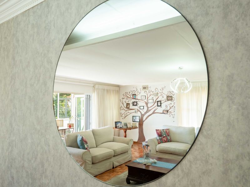 A bright living room featuring parquet flooring, ceiling cornicing, and large sliding glass doors that provide access to the outdoor area.