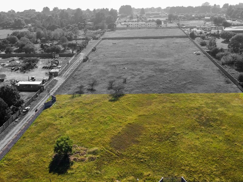 An aerial view of a large, vacant residential plot of land, enclosed by perimeter walls, offering significant development potential.
