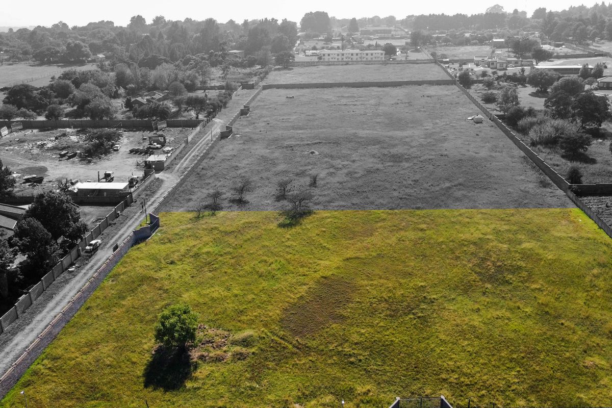 An aerial view of a large, vacant residential plot of land, enclosed by perimeter walls, offering significant development potential.