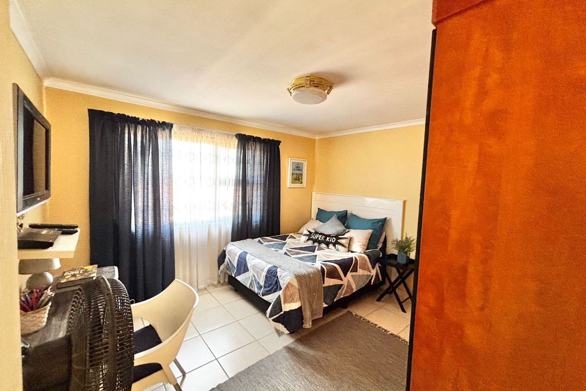 A functional bedroom featuring tiled flooring, neutral wall finishes, and a central ceiling light fixture, providing a comfortable and practical living space.