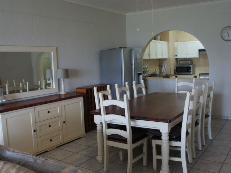 Open plan dining area featuring tiled flooring and a distinctive arched opening leading into the kitchen space.