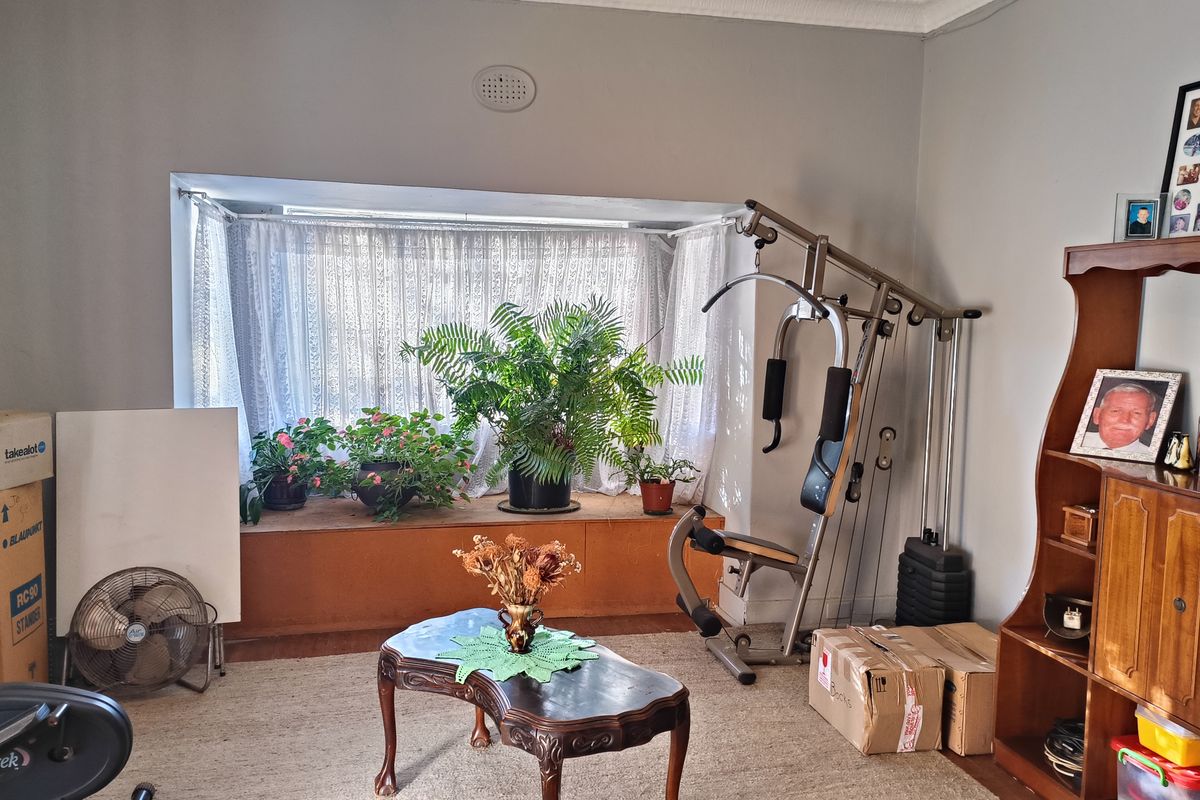 A living room featuring a large bay window with natural light, providing a versatile space for relaxation or potential home office use.