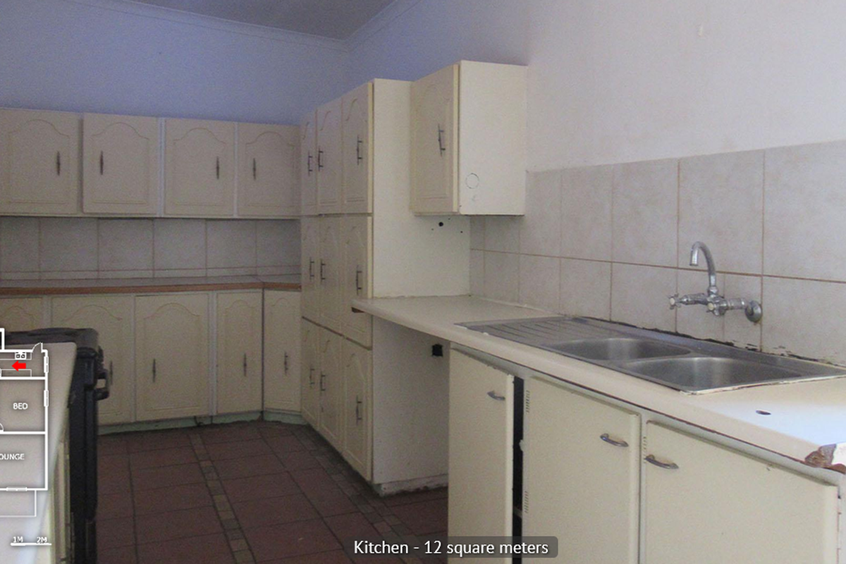 A dated kitchen featuring built-in cabinetry, a double bowl sink, and tiled backsplash, offering a functional layout ready for modernization.