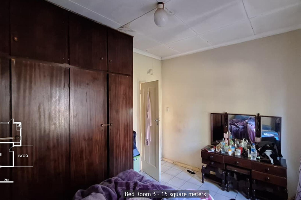 Bedroom featuring built-in wooden cupboards and tiled flooring, requiring ceiling repairs and general cosmetic updates.