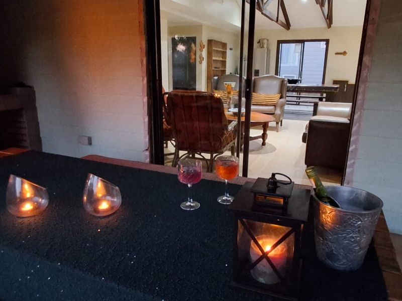 A covered patio area featuring a built-in brick fireplace and sliding glass doors providing access to the interior living space.