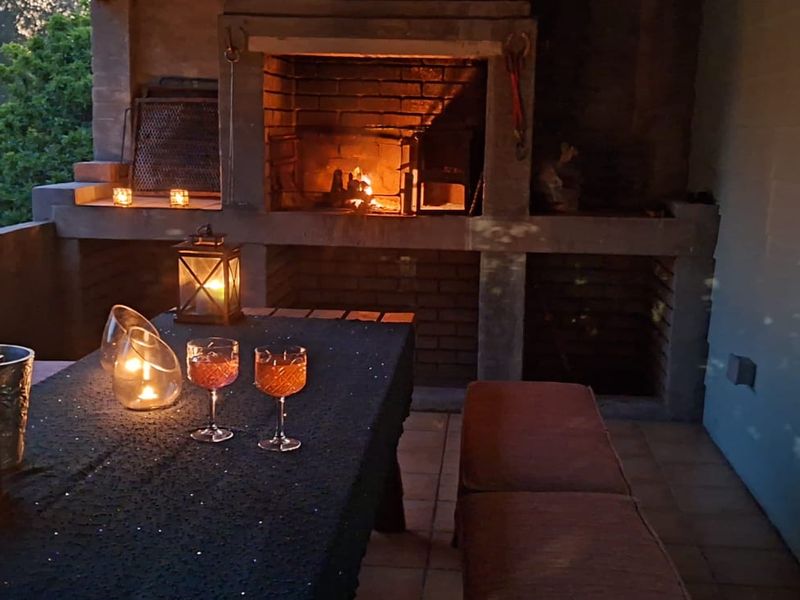 A covered patio area featuring a built-in brick fireplace, ideal for outdoor entertaining and evening relaxation.