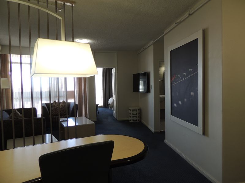 A living area featuring a metal room divider, built-in lighting, and a wall-mounted television, providing a functional and connected space.