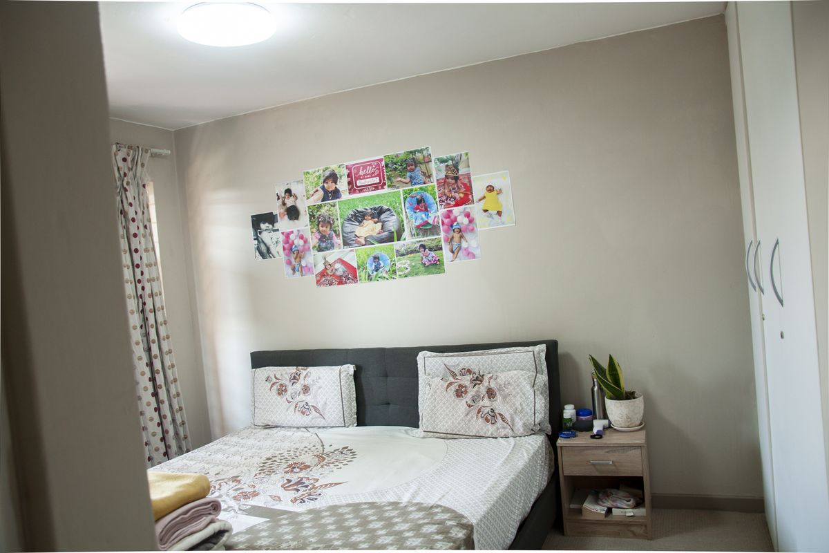 A well-maintained bedroom featuring neutral wall tones, built-in wardrobe storage, and carpeted flooring, offering a comfortable and functional living space.