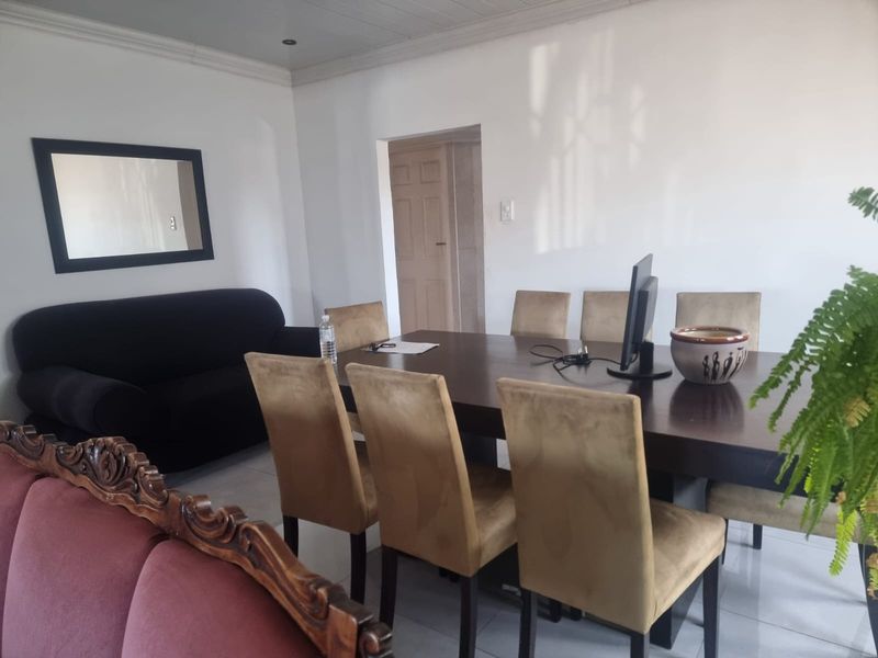 A functional dining room featuring tiled flooring and coved ceiling details, providing a neutral space for family meals and gatherings.