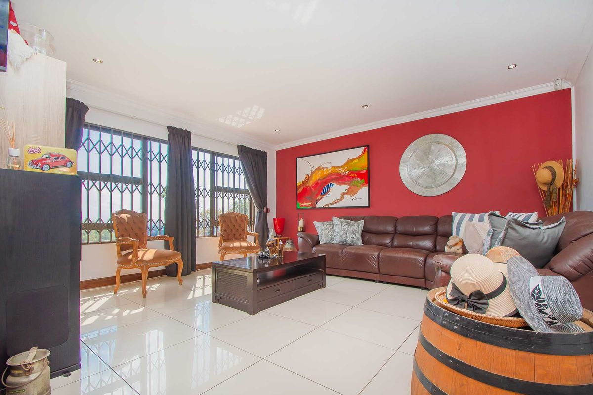 Spacious living room featuring large windows with security gates, polished tiled flooring, and recessed downlighting, creating a bright and functional family space.