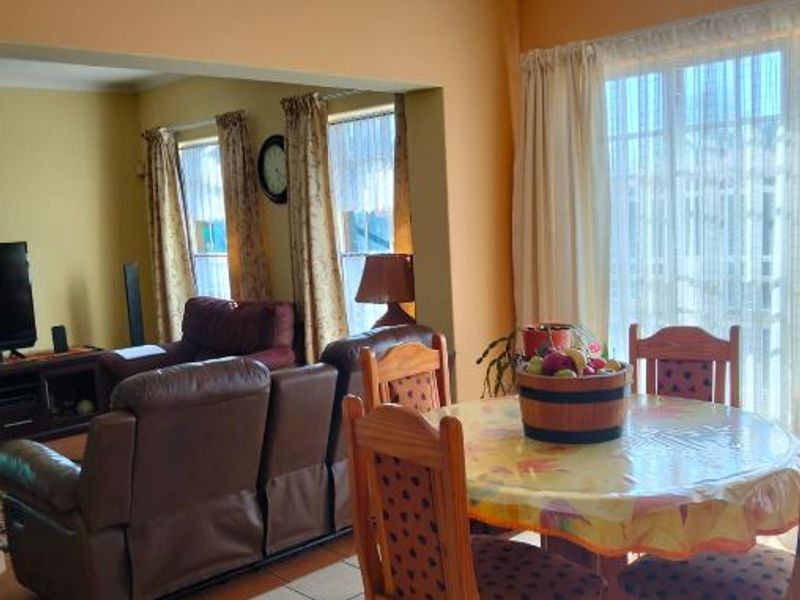 Open plan living and dining area featuring tiled flooring and a sliding glass door providing natural light.