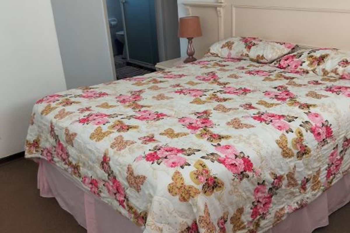 A bedroom featuring a built-in headboard and direct access to an en-suite bathroom.