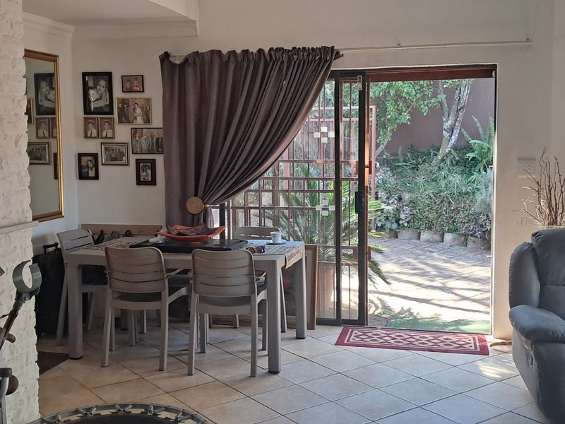 Open plan living and dining area featuring a brick fireplace and sliding glass door access to the rear patio and garden.