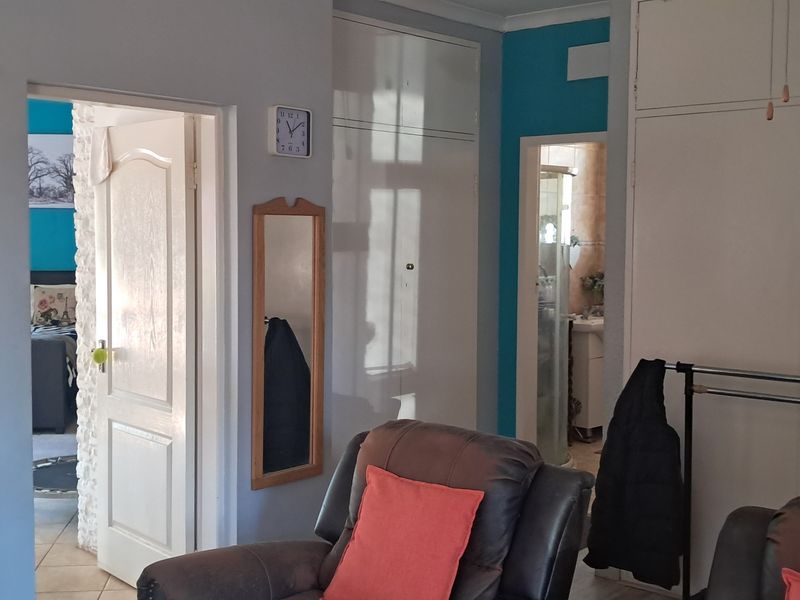 A bedroom featuring built-in cupboards, tiled flooring, and direct access to an adjoining bathroom and another room.