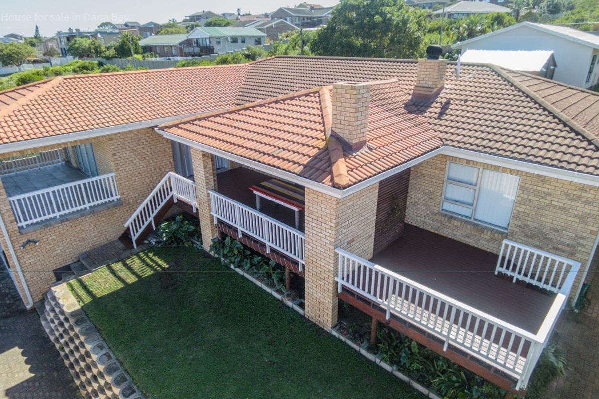 Aerial view of the property showing the rear elevation, featuring a raised timber deck, brick facade, and tiled roof structure.