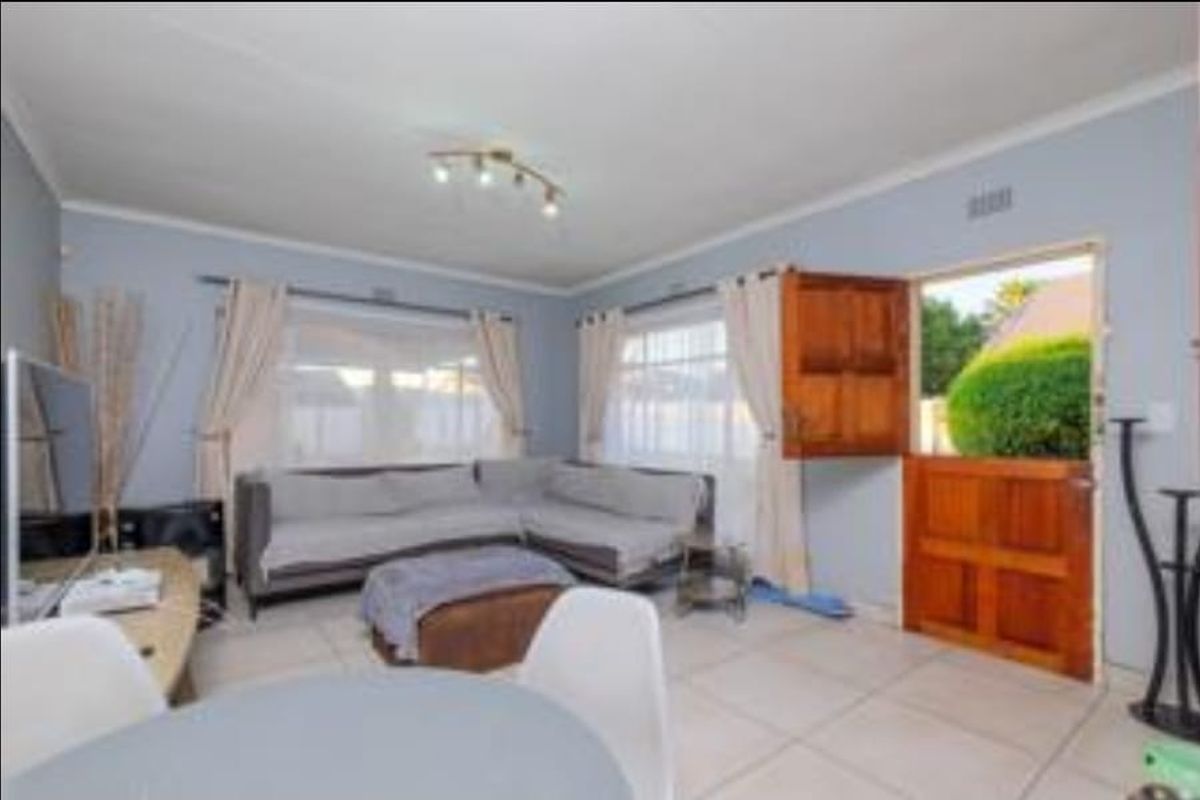A bright living room featuring tiled flooring and a traditional wooden stable door providing direct access to the garden.