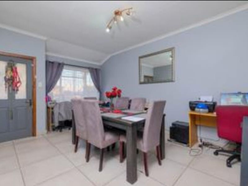 A functional dining area featuring tiled flooring and neutral wall finishes, providing a versatile space for family meals and daily activities.