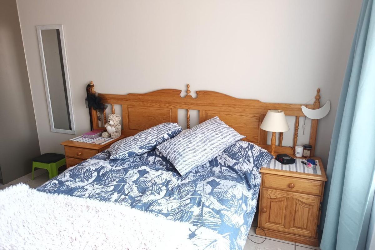 A bedroom featuring tiled flooring and neutral wall finishes, providing a functional space for rest.