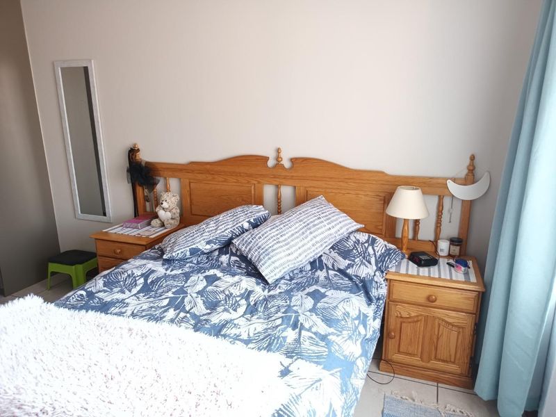 A bedroom featuring tiled flooring and neutral wall finishes, providing a functional space for rest.