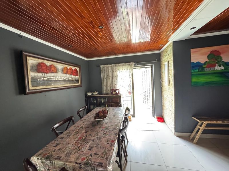 Dining room featuring a polished timber-clad ceiling, tiled flooring, and direct access to an outdoor area through a sliding glass door.