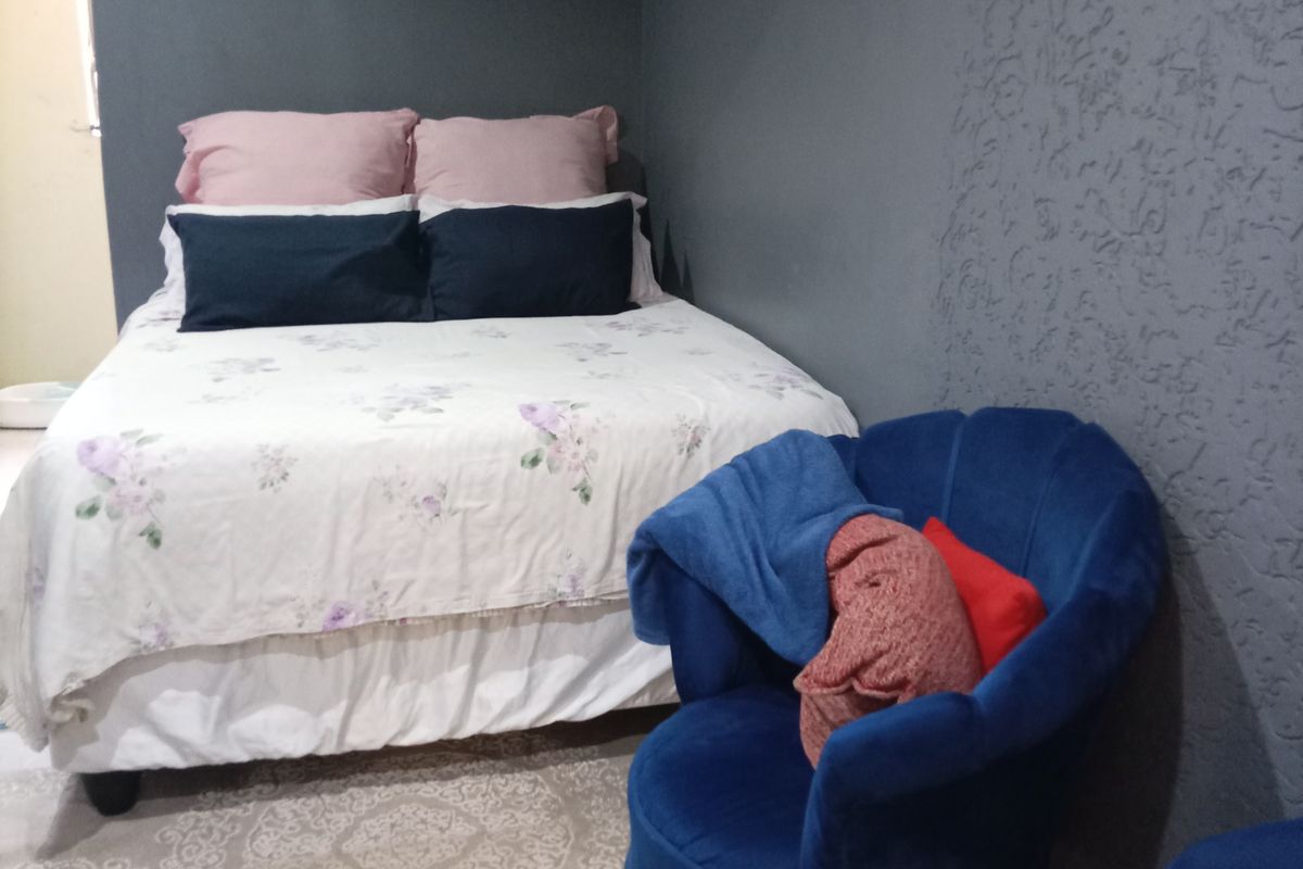 A bedroom featuring dark grey textured walls and neutral flooring, providing a cozy and private sleeping space.