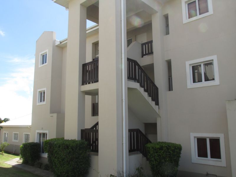 Exterior view of an apartment building featuring a multi-level staircase with dark timber balustrades and neutral-toned facade finishes.