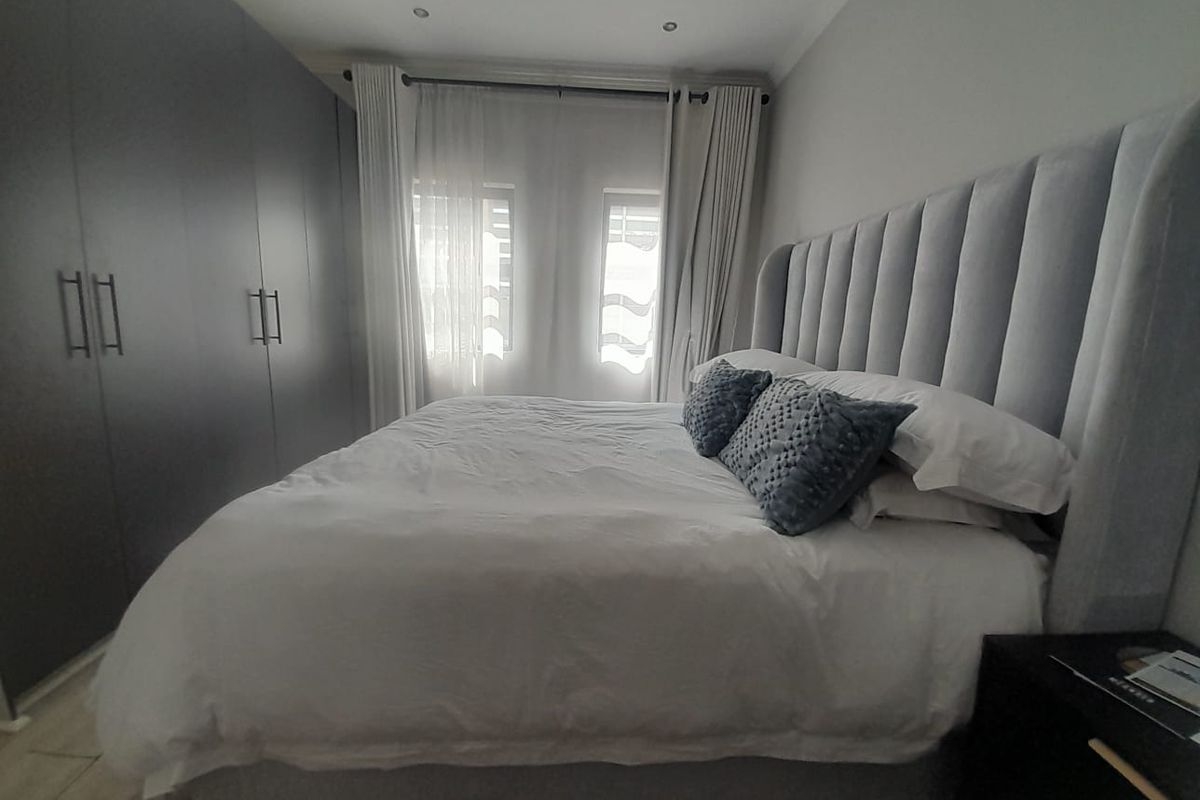 A well-maintained bedroom featuring extensive built-in cupboards and recessed ceiling lighting, creating a clean and functional living space.