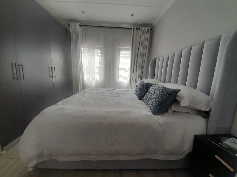 A well-maintained bedroom featuring extensive built-in cupboards and recessed ceiling lighting, creating a clean and functional living space.