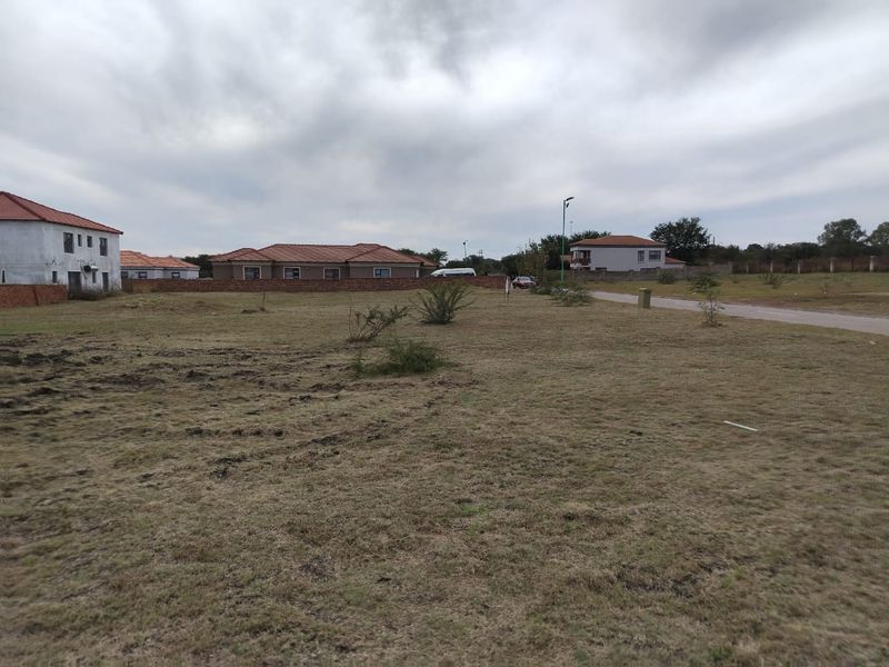 A view of a vacant residential plot of land in a developed neighborhood setting.