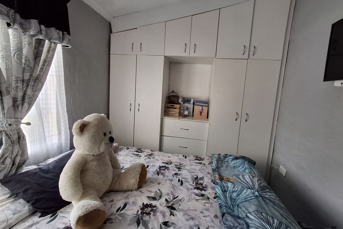 A bedroom featuring built-in floor-to-ceiling cabinetry with integrated shelving and drawers, providing ample storage space.