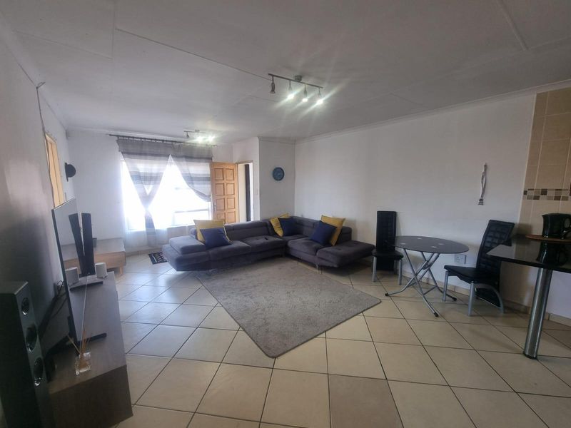 Open-plan living and dining area featuring tiled flooring, recessed lighting, and direct access to the exterior.